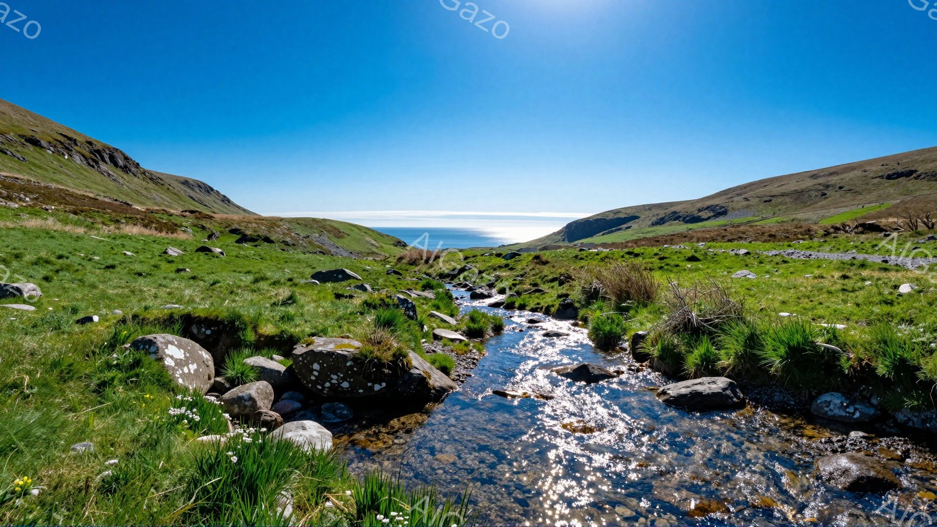 鮮やかな緑の草が茂る丘陵地帯を、細い流れが縫うように流れている。背景には青い海が広がり、太陽の光が水面に反射してキラキラと輝いている。穏やかで静かな雰囲気が感じられる、自然豊かな風景だ。