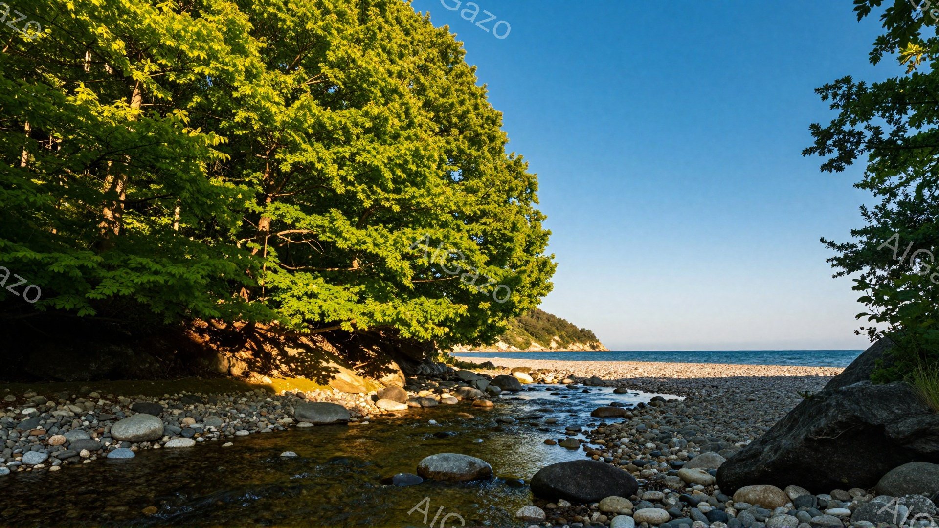 澄んだ青空の下、小石と砂利でできた海岸に細い川が流れ込んでいる。川の両側には緑豊かな木々が生い茂り、太陽の光が差し込んで明るい雰囲気を醸し出している。穏やかな波の音と鳥のさえずりが聞こえてきそうな、静かで平和な風景だ。