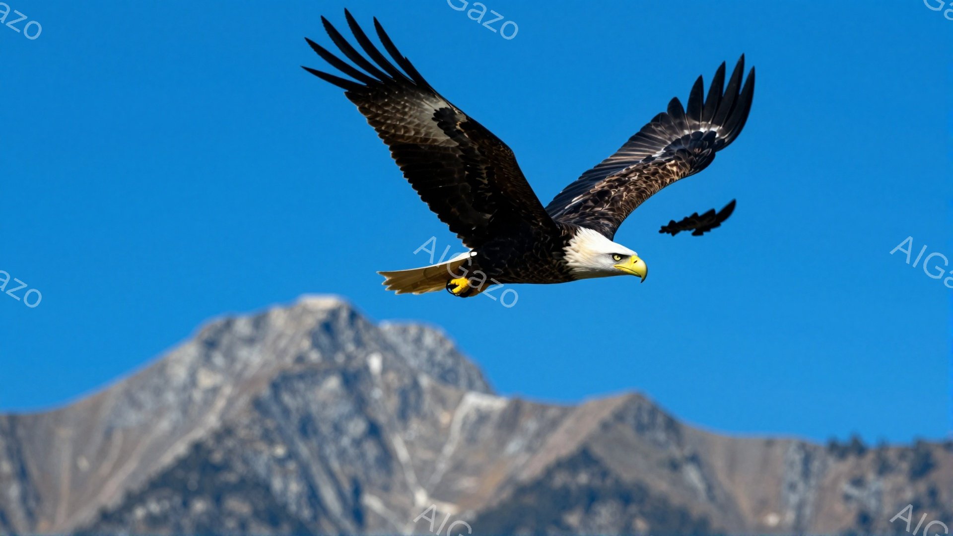 青い空を背景に、翼を広げた白頭ハゲワシが力強く飛んでいる。その鋭い眼差しと力強い翼は、自然の力強さと自由さを象徴している。遠くには雪を頂く山々が連なり、雄大な自然の風景が広がっている。
